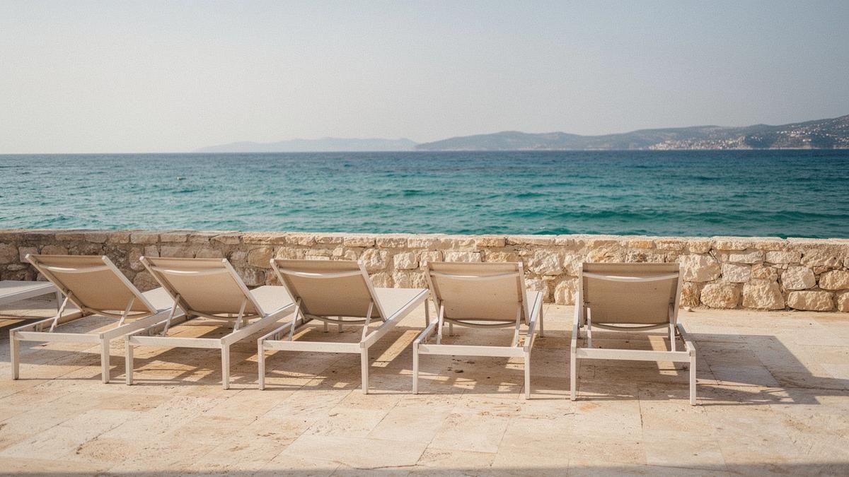 Beachfront hotel terrace with sun loungers facing the sea in the early afternoon